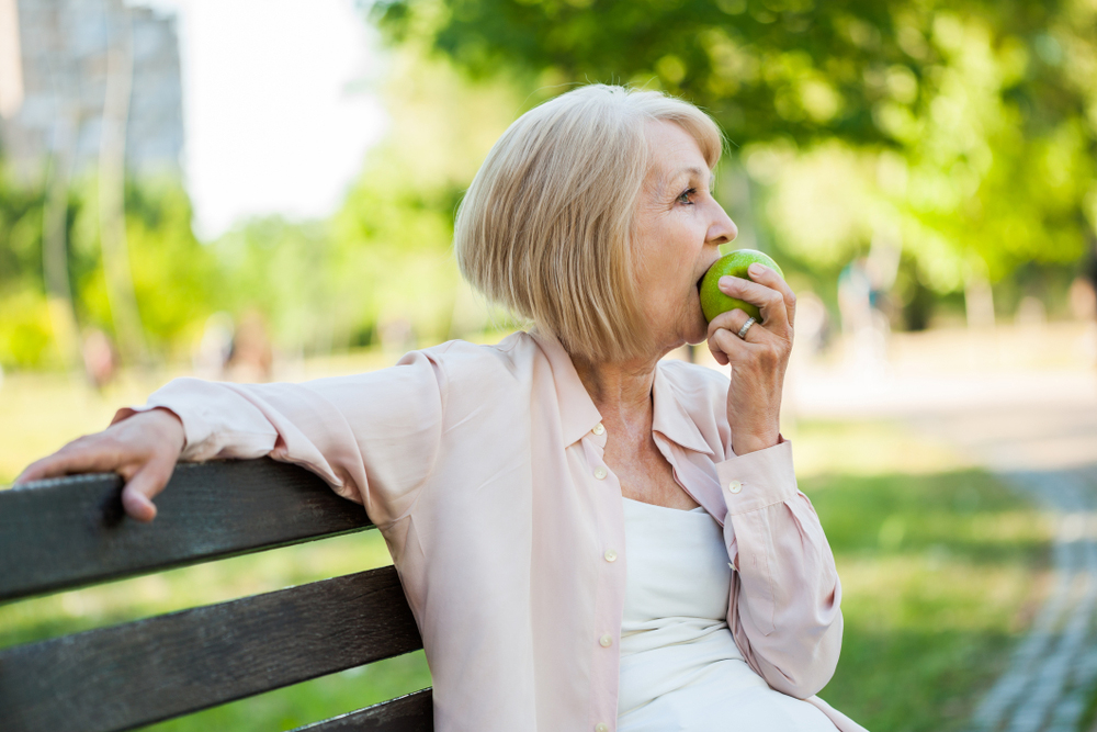 woman eating an apple on a bench in auburn, ca
